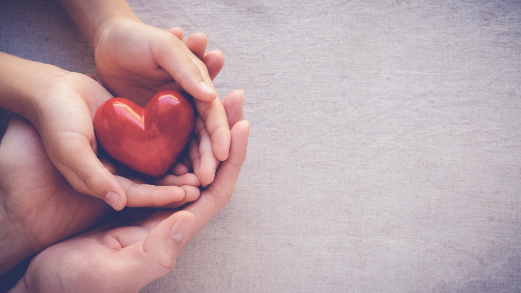 Hands holding a heart symbolising family protection